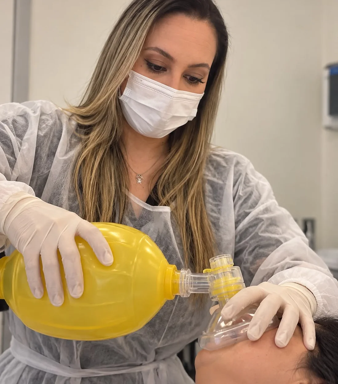 Fonoaudióloga aplicando o ressuscitador manual em uma paciente